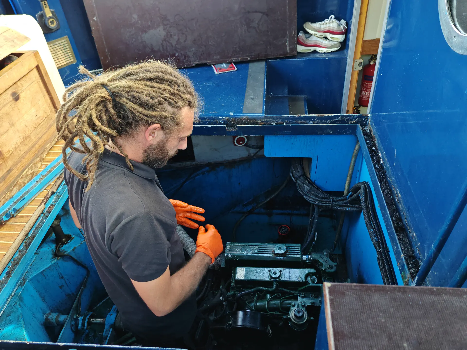 Oli working in the engine bay of a Thames boat servicing a marine diesel